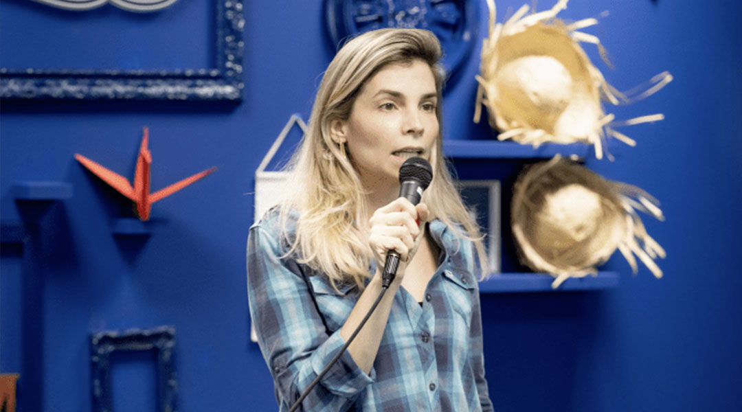 Mulher loira falando ao microfone