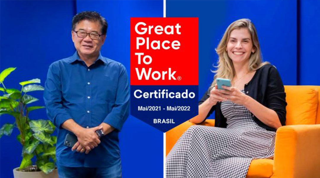 Homem oriental sorrindo à esquerda e mulher loira ocidental sorrindo à direita com selo GPTW ao centro da imagem.